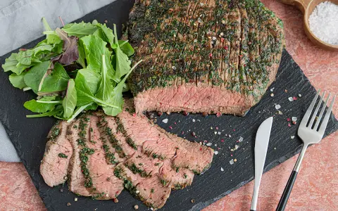 Perfekt mariniertes Flanksteak, aufgeschnitten und mit frischem Salat serviert. Ein Genuss für jeden Fleischliebhaber.