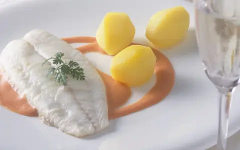 Ein zartes Steinbuttfilet mit Petersilie, serviert mit Salzkartoffeln und einer cremigen Sauce. Der feine Steinbutt Geschmack verspricht ein kulinarisches Erlebnis.