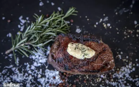 Perfekt medium gegrilltes Steak mit Kräuterbutter, Rosmarin und grobem Salz.